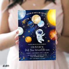 a woman in a pink dress holding up a card with an image of the moon and planets on it