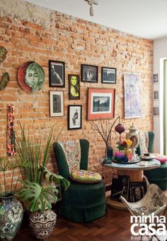 a living room filled with lots of furniture and pictures on the brick wall above it