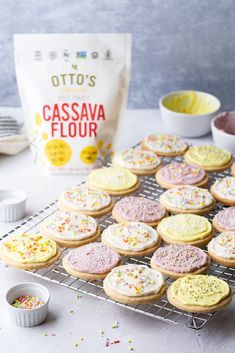 there are many cookies on the cooling rack next to some confetti and sprinkles