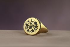 Embrace the timeless beauty of nature with this Engraved Flowers Bold Statement Round Signet Ring, a perfect expression of elegance and femininity. Designed for women who appreciate the delicate intricacies of floral designs, this ring features a round signet adorned with beautifully engraved flowers, making it an ideal gift for the nature-loving woman in your life. Crafted with care and precision, this piece combines the bold statement of a signet ring with the gentle allure of nature, offering Classic Round Birth Flower Jewelry, Classic Yellow Gold Flower Ring As Gift, Classic Yellow Gold Flower Ring For Gift, Elegant Signet Ring With Birth Flower For Anniversary, Elegant Anniversary Signet Ring With Birth Flower, Elegant Yellow Gold Engraved Ring With Birth Flower, Elegant Gold Signet Ring With Birth Flower, Elegant Oval Engraved Flower Ring, Engraved Yellow Gold Flower Ring For Formal Occasions