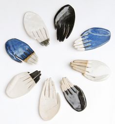 nine different sized and colored hair combs arranged in a circle on a white surface