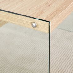 a close up of a wooden table with glass top and drawer on carpeted floor