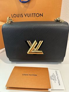 This beautiful Louis Vuitton Twist Shoulder Bag is crafted from high-quality black leather with a stylish Epi finish. It features a magnetic closure and a gold metal handle with a 21.2-inch strap drop. The bag measures 9 inches in width, 6.7 inches in height, and 3.7 inches in depth, making it the perfect medium-sized accessory for any occasion. The bag's interior is lined with black microfiber and features a luxurious gold hardware color. It has a rectangular shape and is part of the Louis Vuitton Twist product line. This elegant shoulder bag is perfect for women who want to add a touch of sophistication to their outfit. Brand new never worn comes with original dust bag and box Louis Vuitton Twist Mm Black, Louis Vuitton Twist, In Depth, Magnetic Closure, Gold Hardware, Gold Metal, The Bag, Dust Bag, Black Leather