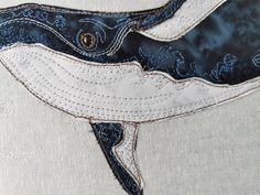 a close up of a piece of cloth with a whale on it's side