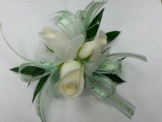 a white rose and green ribbon corsage