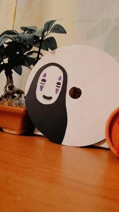 a wooden table topped with a white mask and potted plant