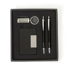 a black box with two pens, a bottle opener and a keychain in it