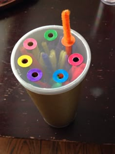 a cup filled with lots of colored pencils and an orange carrot sticking out of it