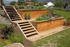 an outdoor garden with steps leading up to the top and bottom planters on each side