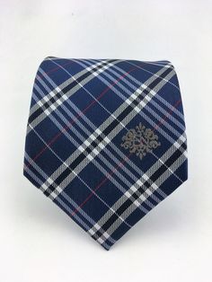 "For the man who loves plaid, Ed's Neckties offers this 100% silk mens plain necktie. Features a navy blue background with blue, gray and red plaid pattern. Available as a extra long tie. Handmade from 100% silk, this special collection features a .75\" Eds Neckties logo at the bottom right front corner of every tie and a larger logo located on the tipping (Back of the tie). The label features the collection name (Nathaniel Alexandria) Named after my son Nathaniel and my daughter Alexandria. Exp Classic Plaid Suit And Tie Accessories For Office, Classic Plaid Business Suit And Tie Accessories, Plaid Suit And Tie Accessories For Business, Classic Plaid Ties For Formal Occasions, Classic Plaid Standard Tie, Fitted Plaid Ties, Navy Suit And Tie Accessories For Business, Make A Tie, White Goth