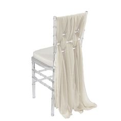 a white chair with a sheer curtain draped over it's back and seat cover