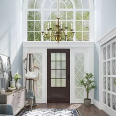 a living room with a chandelier hanging from the ceiling and a rug on the floor