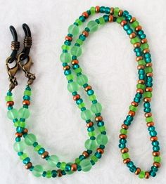 Green & Brown Beaded Eyeglass Chain 25" in length, made with glass beads, beading cord, metal lobster clasps, and adjustable rubber holders. Lobster clasps make it easy to change the rubber holders, and an extra pair of holders are included with every purchase. You can convert this eyeglass chain into a convenient mask chain as well! Simply remove the rubber holders from the lobster clasps, and replace them with face mask straps, as shown. You'll never mis-place your mask again, and always have Adjustable Green Double Strand Beaded Necklace, Adjustable Round Beaded Necklaces For Everyday, Adjustable Green Necklace For Everyday Use, Adjustable Colorful Beaded Jewelry For Everyday Use, Everyday Adjustable Green Necklace, Adjustable Beaded Chain Necklace For Everyday, Adjustable Czech Glass Beaded Necklaces With Lobster Clasp, Adjustable Round Bead Glass Necklaces, Adjustable Green Czech Glass Beaded Necklaces