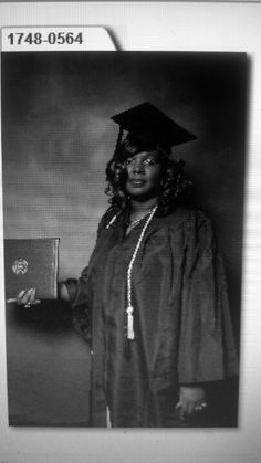 a black and white photo of a woman in graduation gown