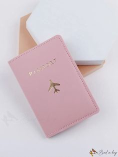 a passport case sitting on top of a white table next to a pink and white box