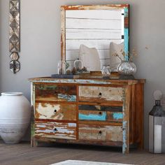 an old dresser with a mirror and vases on it