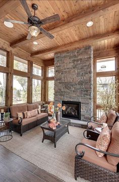 a living room filled with furniture and a fire place in front of a stone fireplace