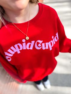 Get cozy and comfortable with our Stupid Cupid Sweatshirt! Made with soft material, this sweatshirt is perfect for lounging. So go ahead, cuddle up and relax in style! Cute Ribbed Cuffs Tops For Loungewear, Cute Tops With Ribbed Cuffs For Loungewear, Cute Loungewear Tops With Ribbed Cuffs, Cute Tops For Loungewear With Ribbed Cuffs, Graphic Print Crew Neck Top For Lounging, Cute Crew Neck Sweatshirt For Loungewear, Cute Sweater With Letter Print For Loungewear, Cute Letter Print Sweater For Loungewear, Comfy Sweatshirt With Letter Print For Loungewear