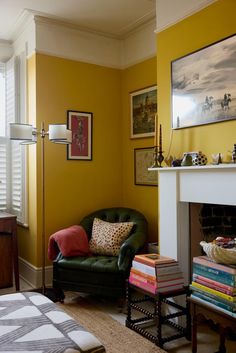 a living room filled with furniture and a fire place next to a wall covered in pictures