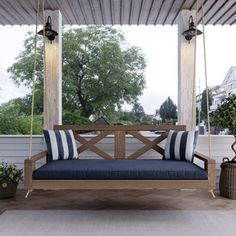 a porch swing with blue cushions on it