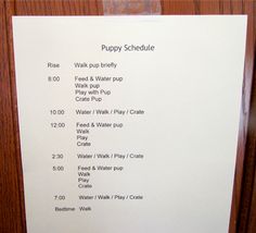 a sign that is on the side of a door with instructions for puppy schedules