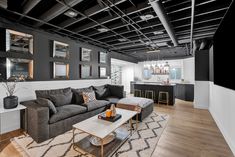 a living room filled with furniture and lots of mirrors on the wall next to a bar