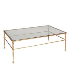 a gold coffee table with glass top and metal legs on an isolated white background,