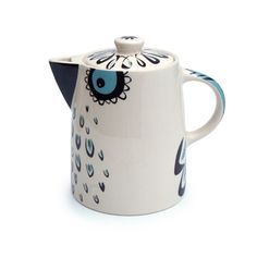 a ceramic tea pot with an owl design on the front and blue eyes painted on the outside