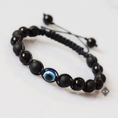 "This Evil Eye bracelet is all about a clean and elegant design. Featuring two types of Black Onyx beads - matte and shiny - and an evil eye protection bead as its centerpiece, this eye bracelet is strung on a waxed cord and is finished off with an adjustable closure. The Evil Eye symbol is an ancient talisman that is believed to ward off evil and protect against misfortune and bad luck. The black color is believed to protect against negativity. Black Onyx is said to help release negative emotio Ancient Talisman, Jewelry Evil Eye, Black Onyx Jewelry, Crystal Bead Jewelry, Eye Symbol, Evil Eye Protection, Bracelet Mens, Onyx Jewelry, Natural Stone Jewelry