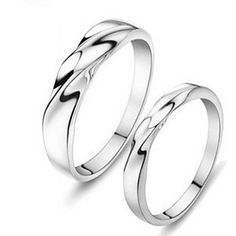 two white gold wedding rings with twisted design on each side, set against a white background