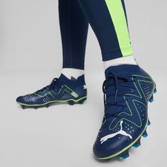 the legs and feet of a person wearing blue shoes with neon green accents on them