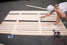 a woman is working on some wood planks