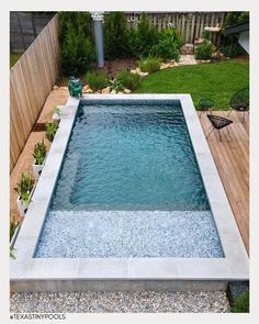 an empty swimming pool in the middle of a backyard with gravel and rocks around it