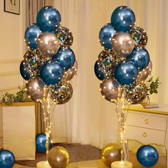 two tall blue and silver balloons are in the middle of a room with other decorations