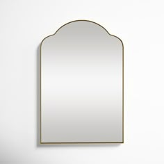 a mirror hanging on the wall in front of a white wall with a black frame