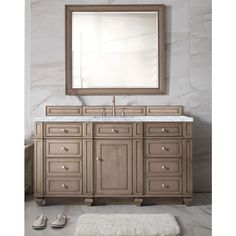 a bathroom vanity with a mirror above it and slippers on the floor next to it