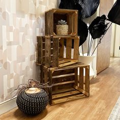 a wooden crate sitting on top of a hard wood floor next to a black and white vase