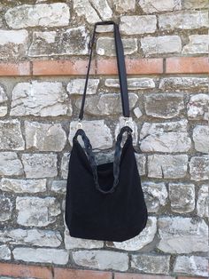 Handmade black suede hobo bag. This bag is unlined, inside there is a big cotton zipped pocket. The bag is closed with a zip The handle is an handmade leather braid. The sholder belt is removable and adjustable. This confortable hobo bag is very practical for any occasion. This bag is very large and soft and may contain many things. Features : - Black suede, - Unined, - Metal finishes are brass colored, - Closed with zip, - Inside zipped pocket, - Removable shoulder belt. Size : - Heigth 16 inch Suede Hobo Bag With Double Leather Handles, Black Hobo Bag With Braided Handles For Daily Use, Everyday Black Hobo Bag With Braided Handles, Black Suede Bag With Detachable Strap, Suede Hobo Bag With Adjustable Double Handle, Versatile Black Bucket Bag With Braided Handles, Black Leather Shoulder Bag With Braided Handles, Black Suede Shoulder Bag For Travel, Black Suede Crossbody Bag