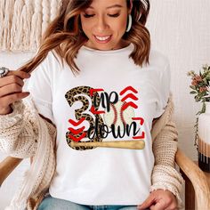 a woman sitting in a chair wearing a t - shirt with the word game day printed on it