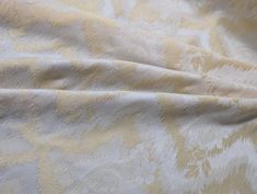 the fabric is yellow and white with an intricate design on it's back side