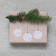 a present wrapped in brown paper with white ornaments hanging from it's side on a concrete surface