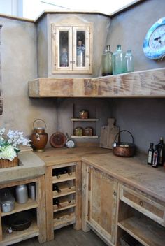 a rustic kitchen with wooden cabinets and shelves