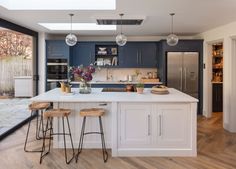 a kitchen with blue cabinets and white counter tops