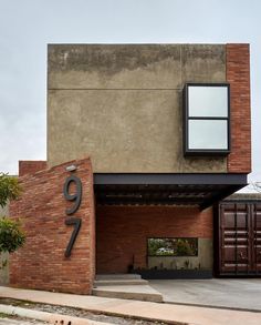 the number twenty seven is displayed in front of a brick building with an open garage door