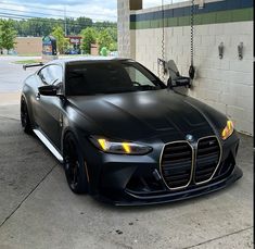 a black sports car parked in front of a gas station with no one around it