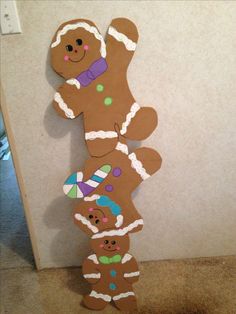 a cardboard cutout of a gingerbread man and his two babies is hanging on the wall