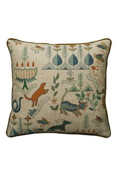 a pillow with animals and plants on it