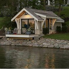 a small house sitting on the side of a body of water