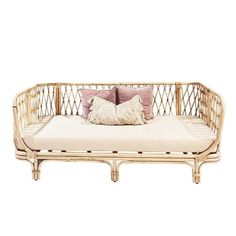 a wicker day bed with two pillows on it