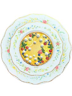 three plates with different designs on them, one has flowers and the other has fruit